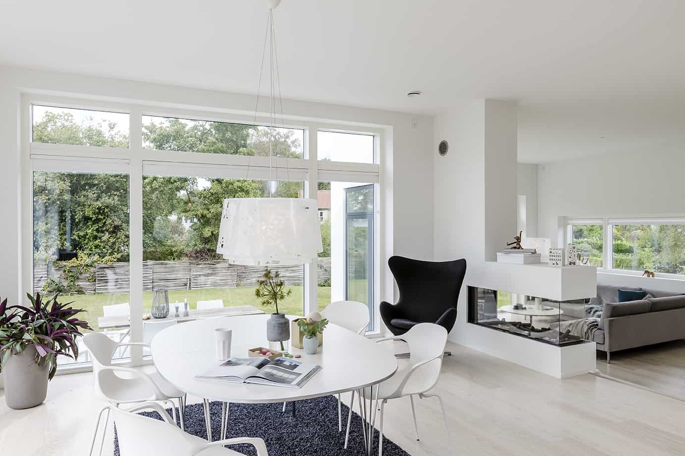 Køkkenalrum i funkis villa med store hvide vinduespartier