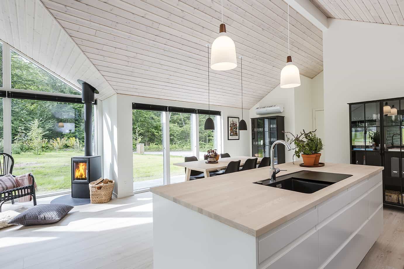Pænt køkken alrum med brændeovn og trælofter