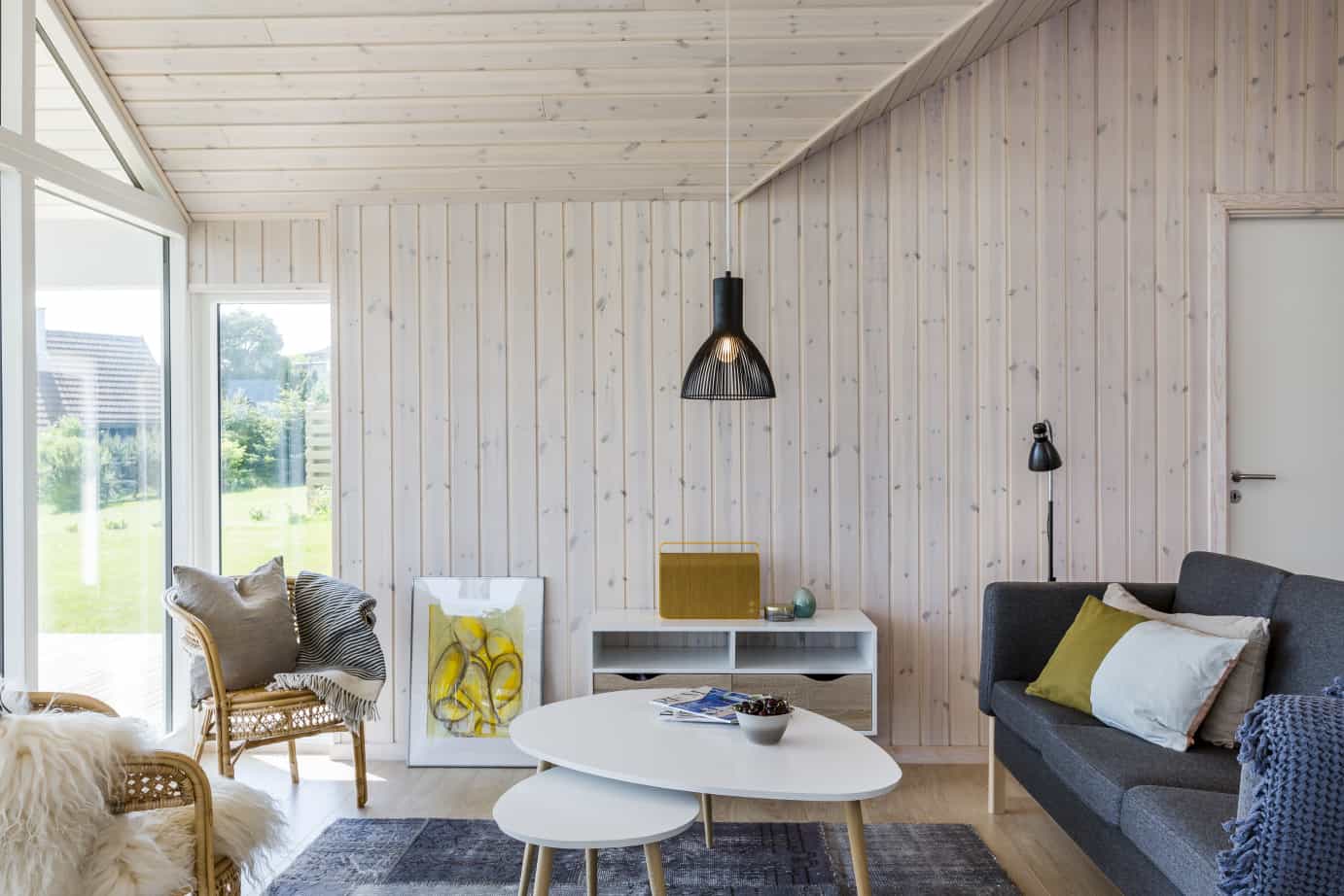 Hyggeligt sofaarrangement i stue med træbeklædte vægge