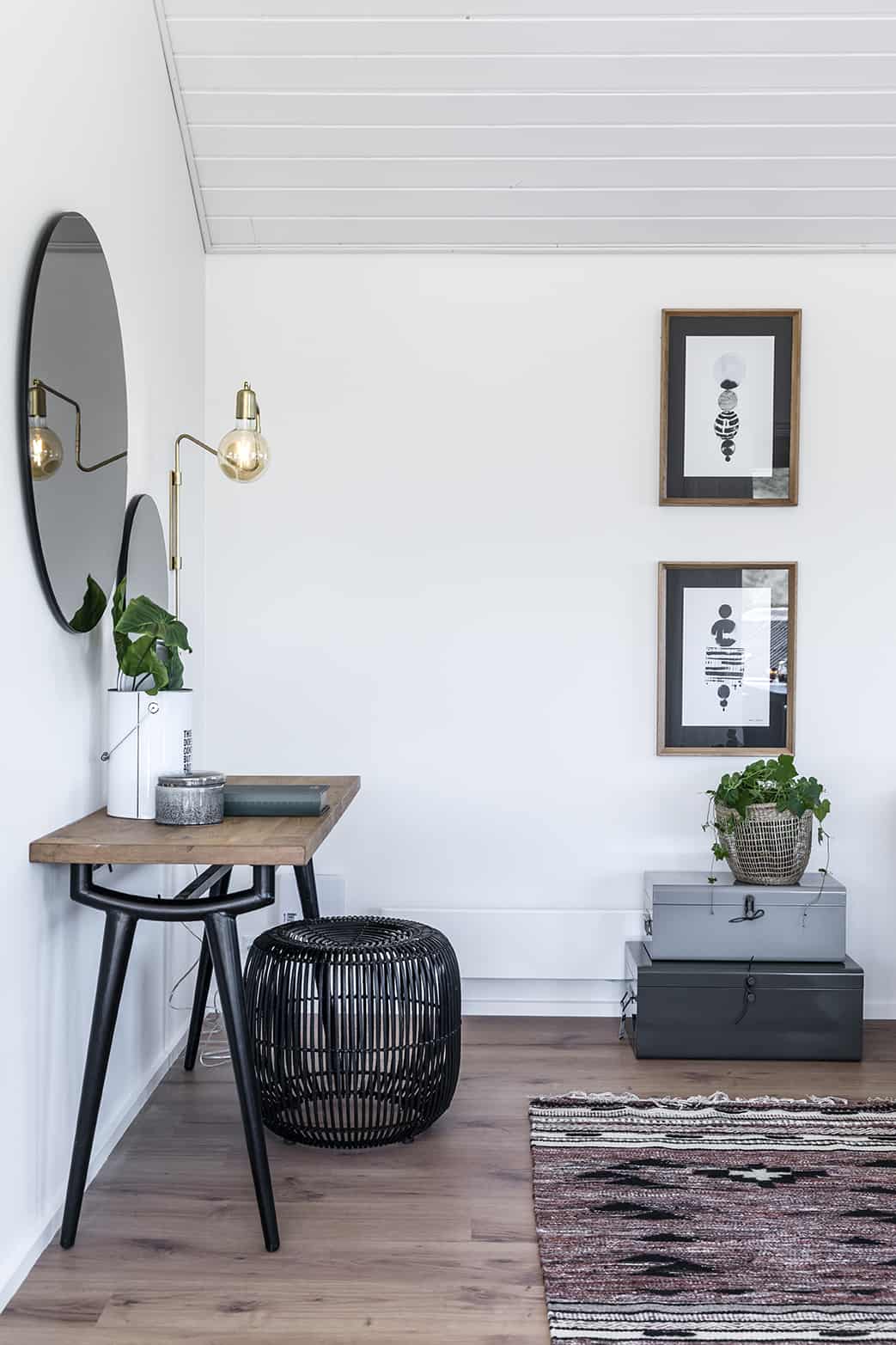 Hjørne af stue med bord, spejl og væghængte billeder