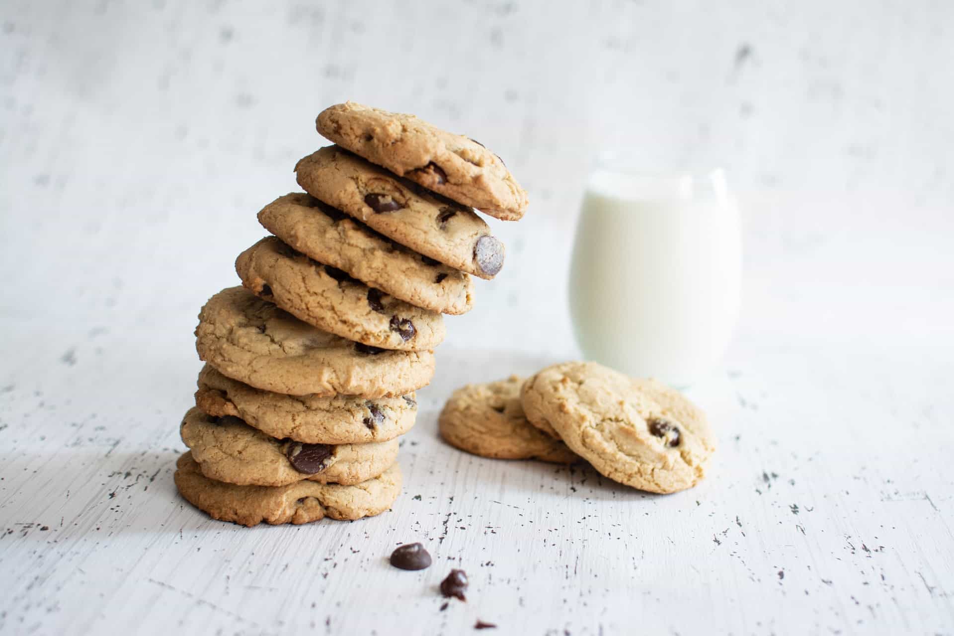 Chokoladecookies på et bord sammen med et glas mælk.