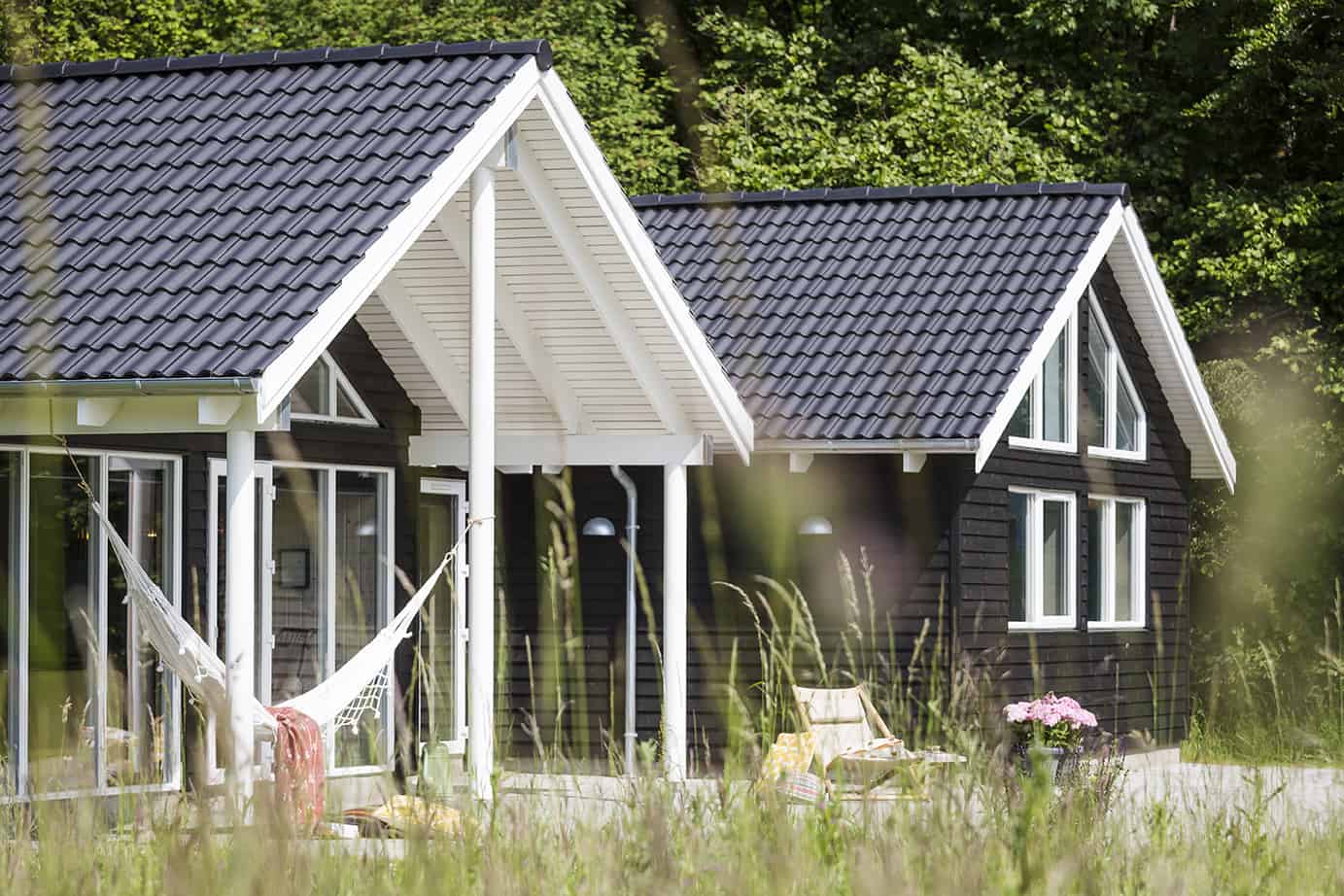 Sommerhus i sort med tegltag set udefra