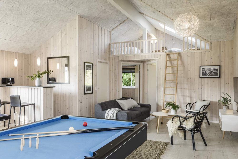 Aktivitetsrum i sommerhus med billard, bar og stige til lys hems