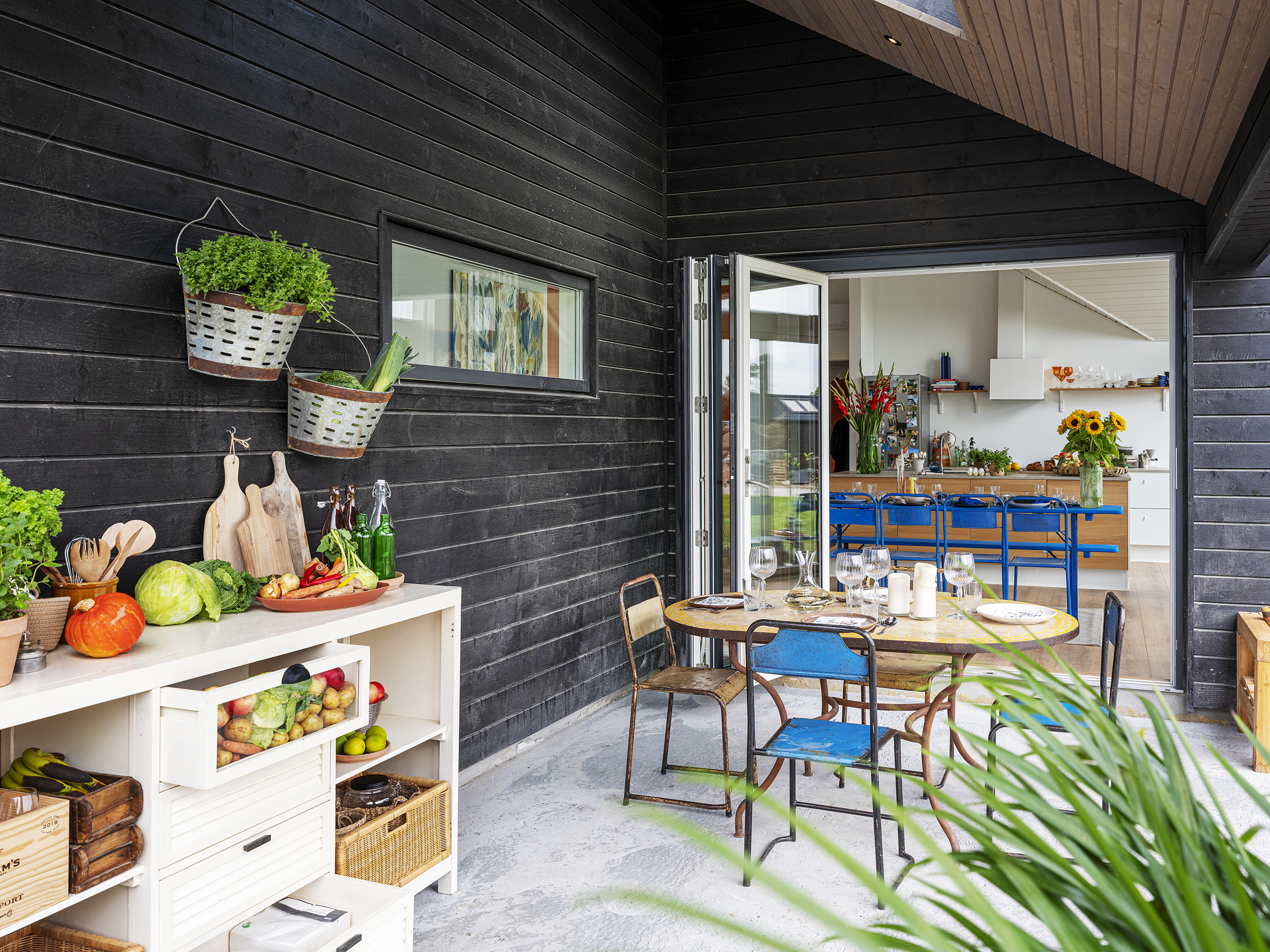 Sommerhus med møbler på terrassen og kig til køkken