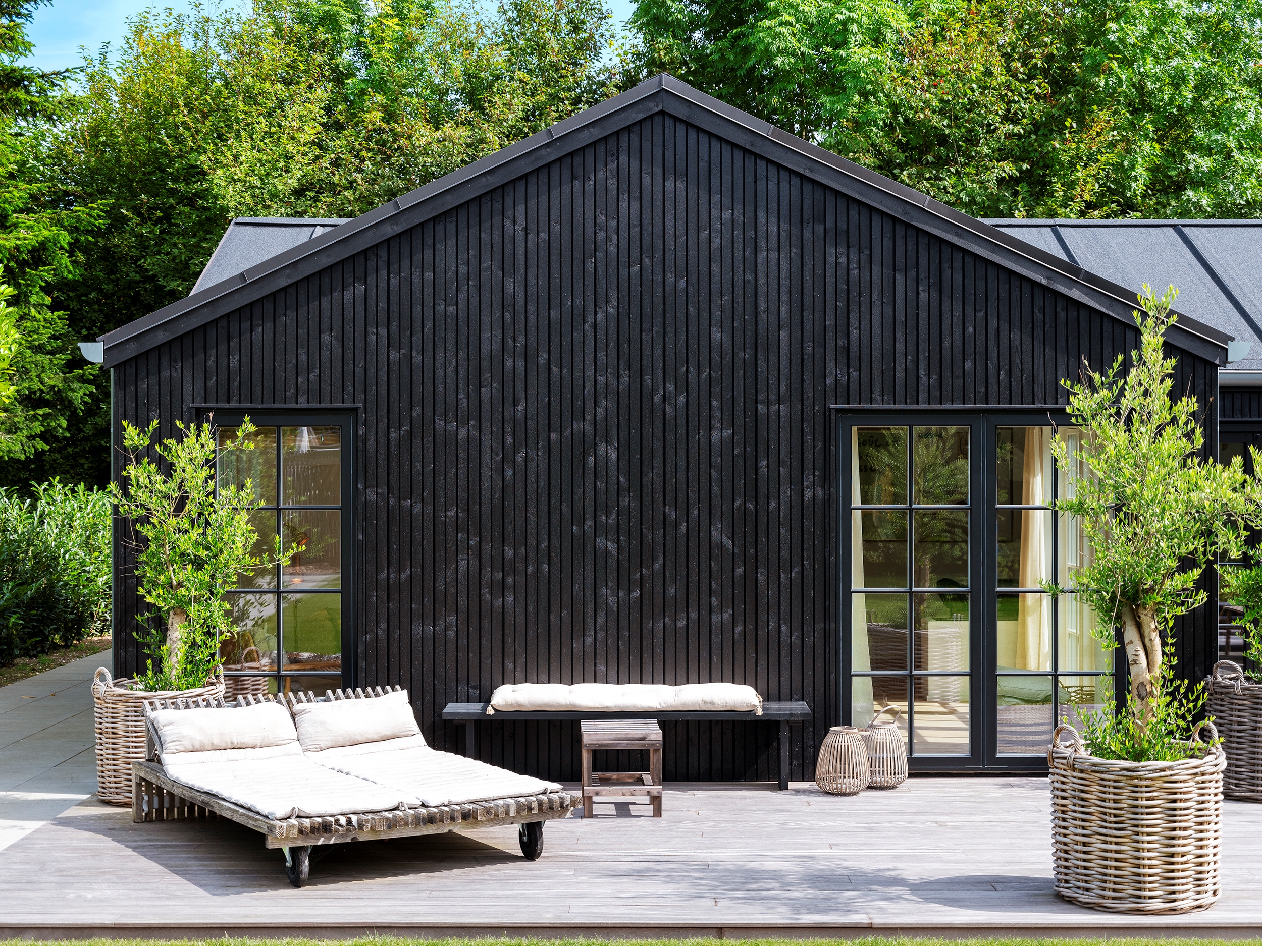 Trend sommerhus med sprossede vinduer set udefra i solskin